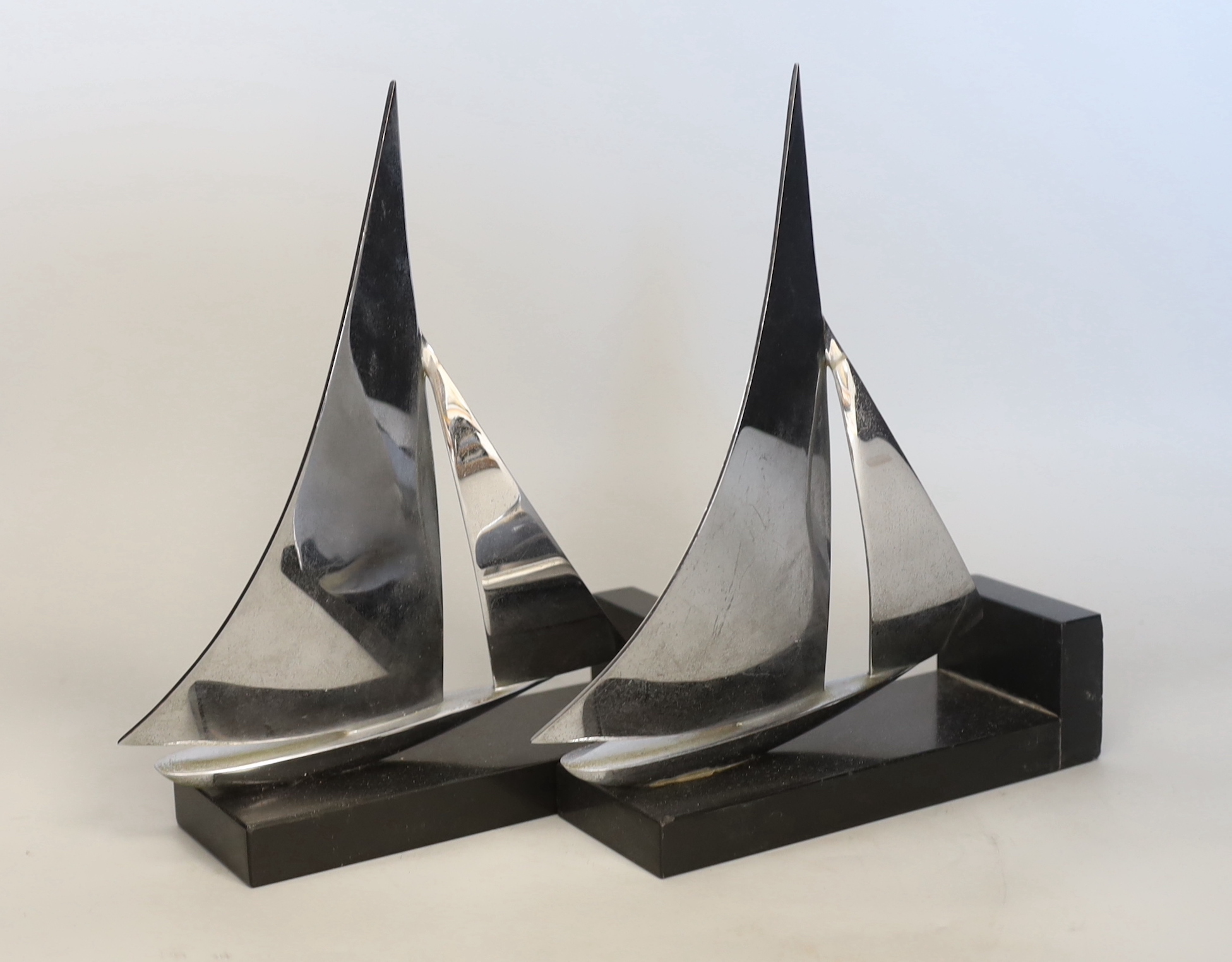 An Art Deco chrome model of a lioness drinking, possibly a car mascot and a pair of chrome yacht bookends, 20cm each wide